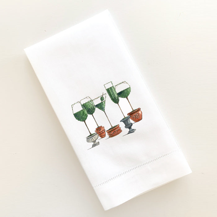 A linen guest towel with a drawing of topiary stemware.