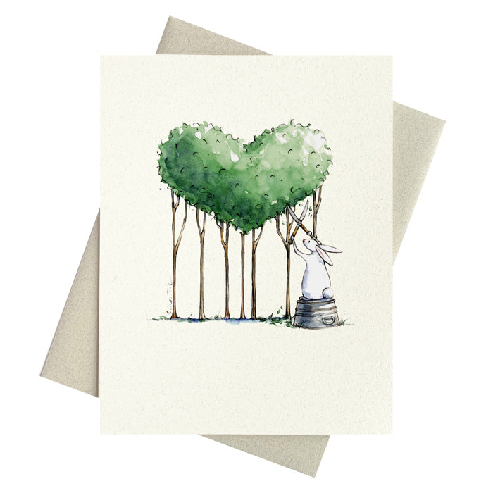 Bunny trimming a topiary heart from a grouping of trees printed on a notecard.